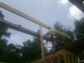 Carpenter setting a ridge beam over a new addition frame — Ice Dam Removal by Roofing Brothers in Hyndman