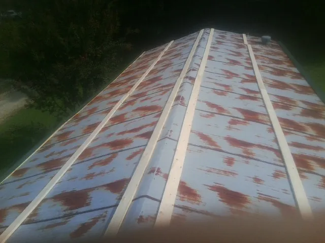 Rusted metal roof panels with new wood purlins before replacement — Storm Damage Roof Repair in Hyndman by Roofing Brothers