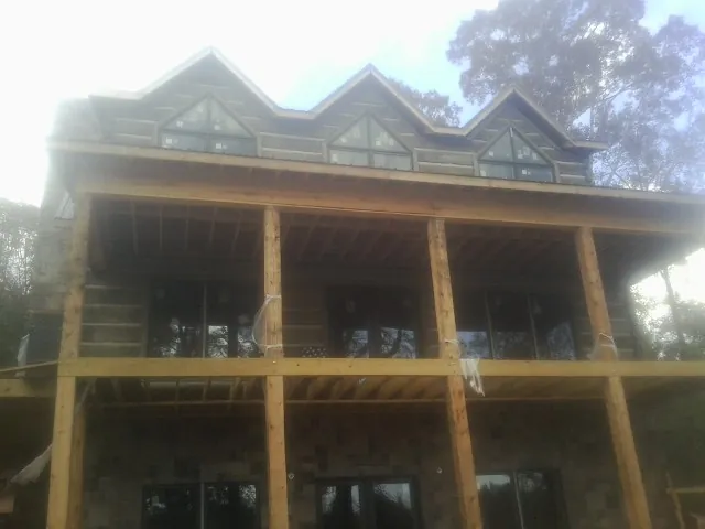 Dormers and porch framing on a large log home under construction — Roof Coating work by our crew in Hyndman