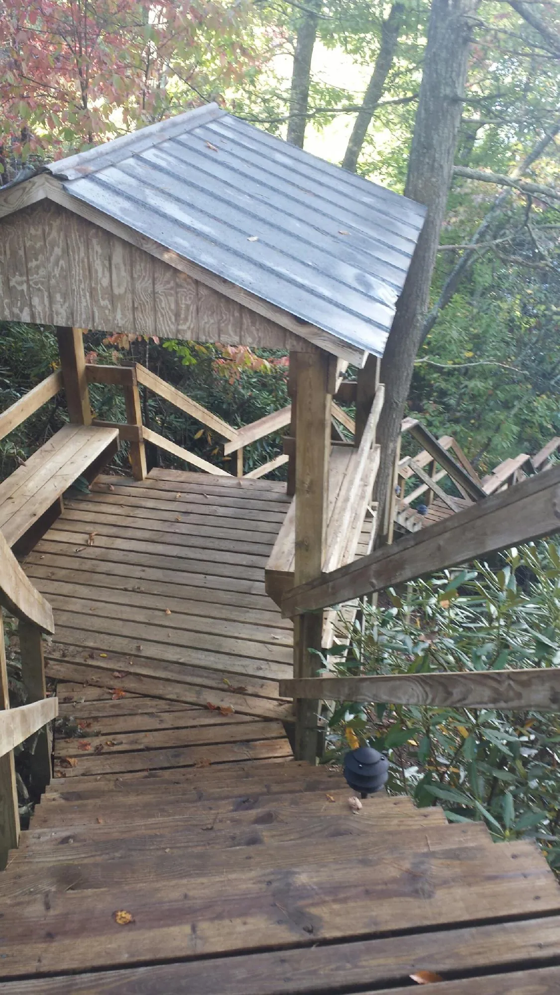 Metal roofed shelter over wooden steps on a wooded walkway — Skylight Repair & Installation work by our crew in Hyndman