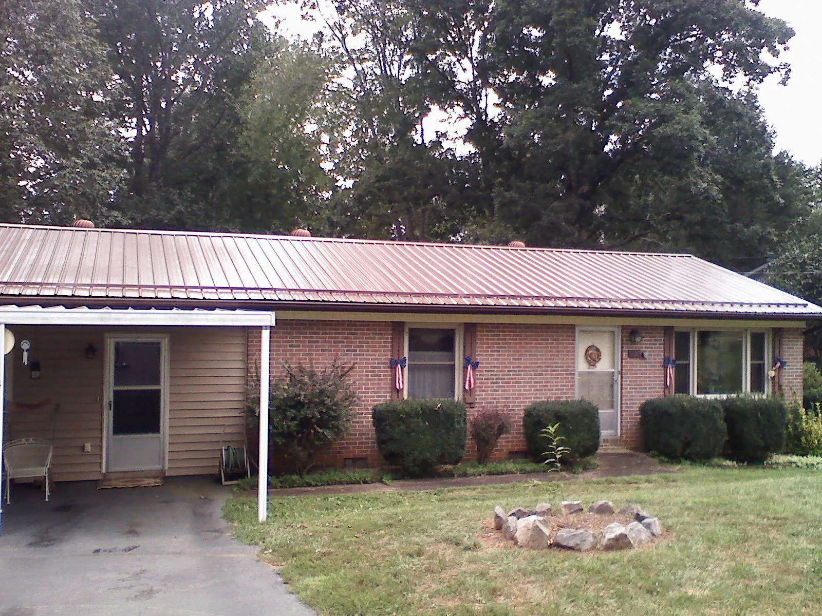 Bronze metal roof and carport on a brick ranch home — Roof Repair work by our crew in Hyndman
